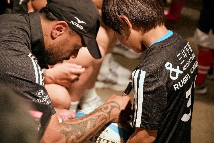 ラグビーボールにサインをする選手