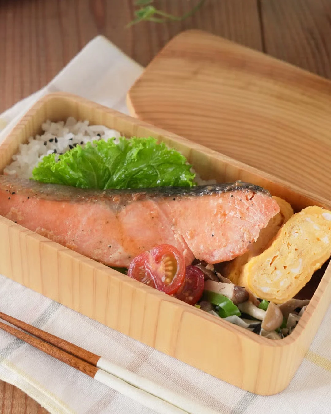 鮭、ご飯、卵焼きなどが美しく盛り付けられた弁当