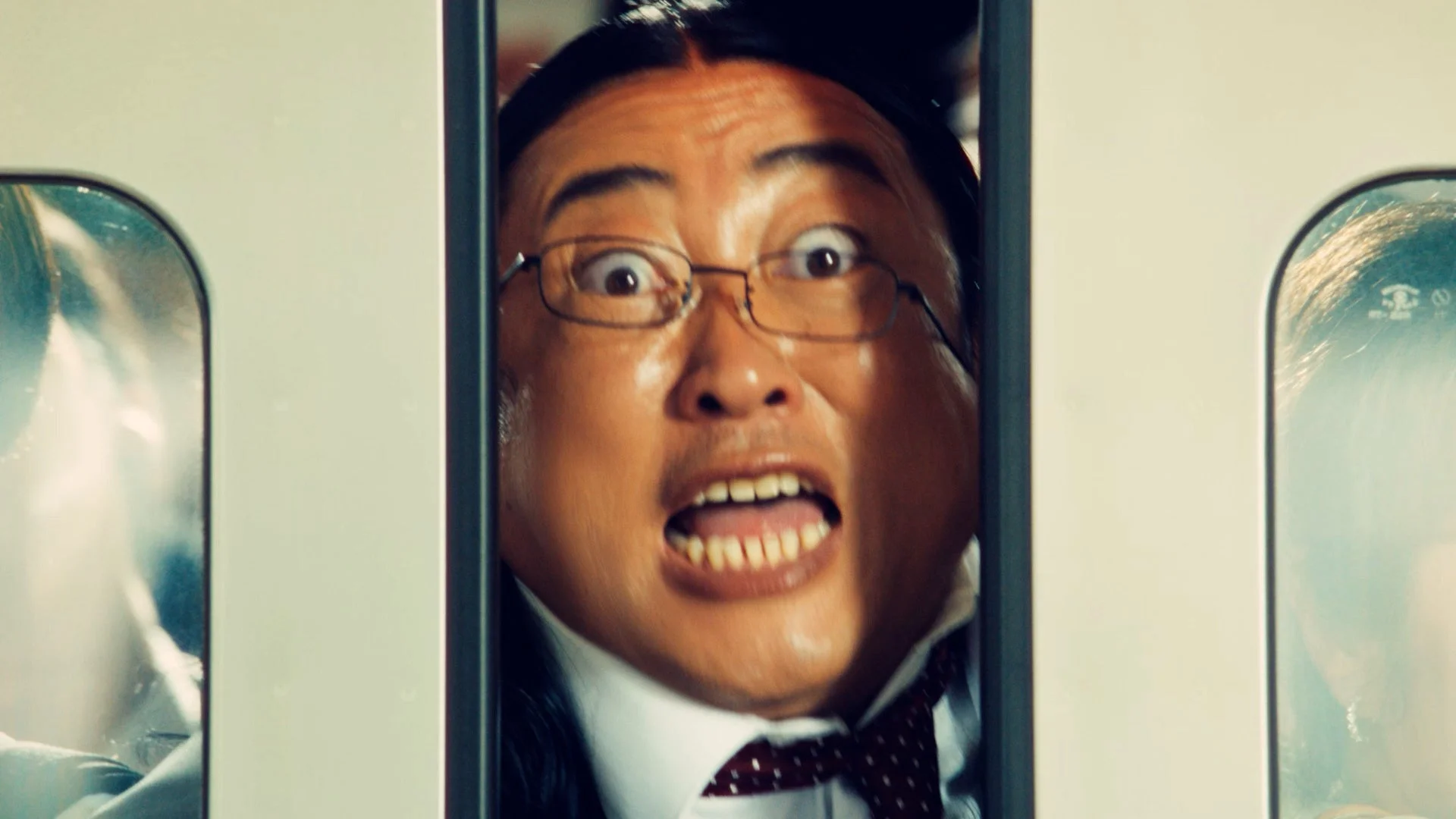 電車のドアに顔を挟まれながらもパックごはんを薦める秋山竜次さん