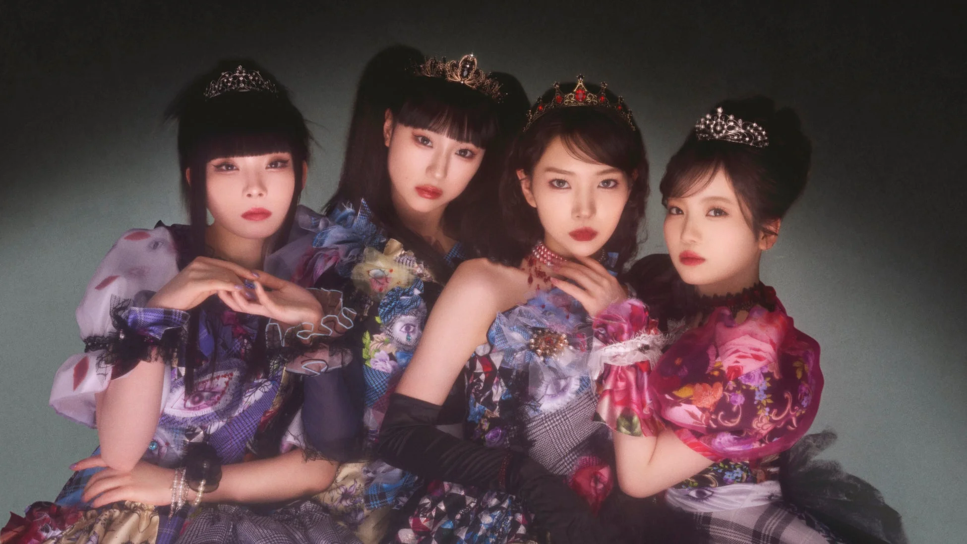 華やかな装飾のドレスとクラウンを身につけた4人の女性が写るポートレート