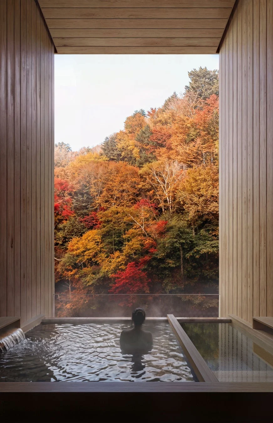 露天風呂から紅葉に染まる山々を眺める様子