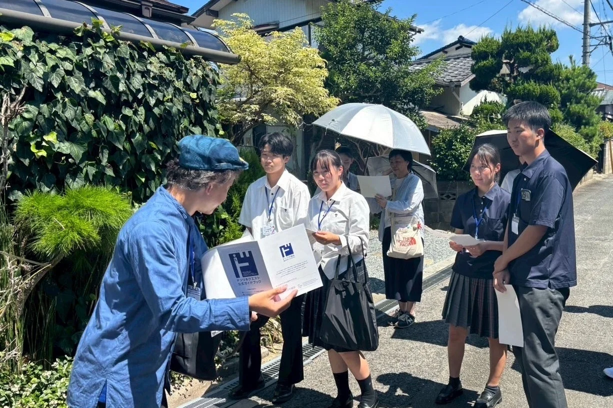 ガイドブックを見ながら説明を受ける学生たち