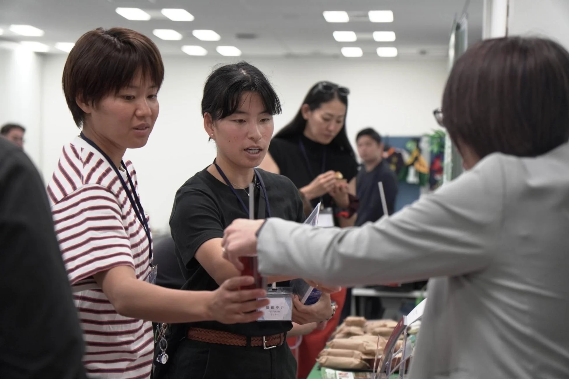 屋内のイベント会場で、複数の人々が集まり交流している様子