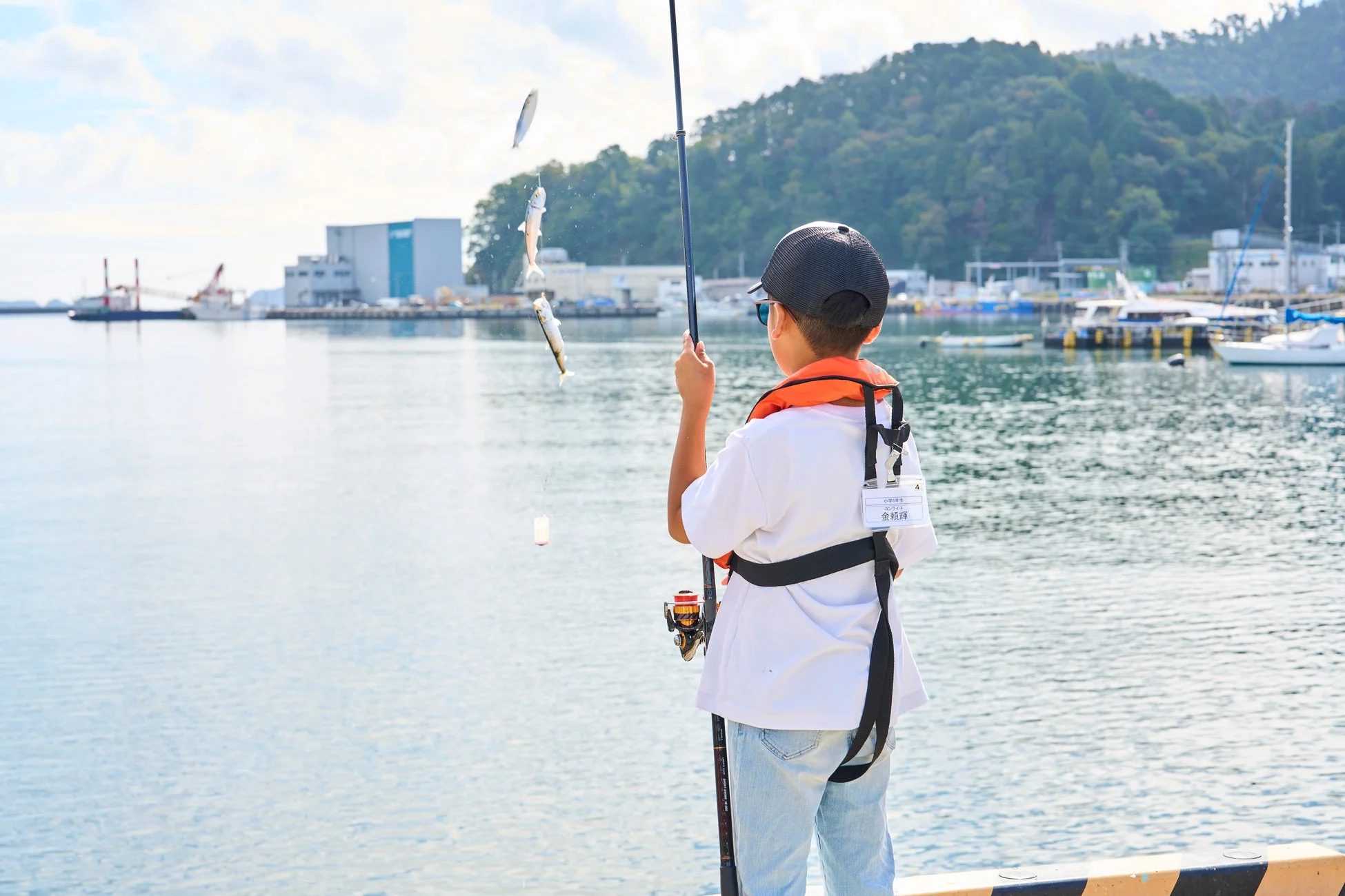 釣り上げた魚を持つ少年