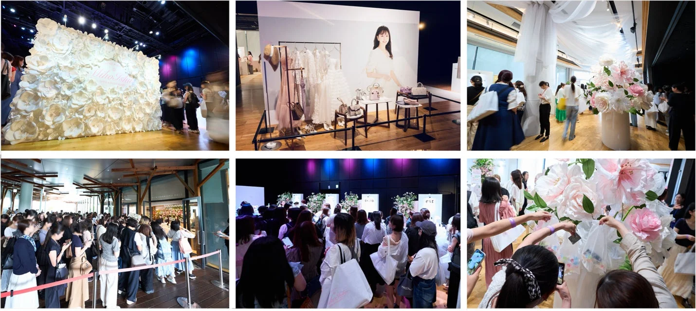 ファッションやライフスタイル製品の展示イベントの様子。巨大な花の装飾、ドレスやバッグの展示があり、多くの来場者が列をなし、展示物と交流している賑やかな光景です。