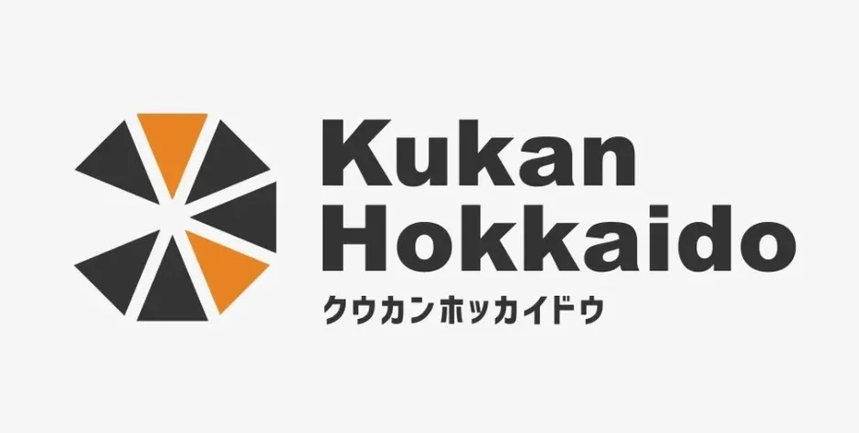 「Kukan Hokkaido」という企業ロゴが描かれた画像です。ロゴはオレンジと黒の三角形を組み合わせた幾何学的なデザインで、その右側に英語とカタカナで社名が表記されています。