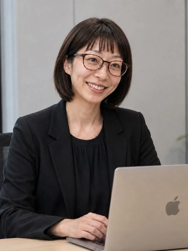 笑顔でノートパソコンに向かう女性ビジネスパーソン