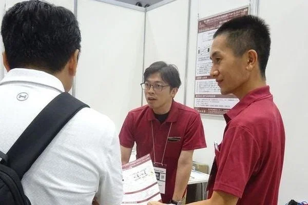 展示会ブースで会話する男性たち
