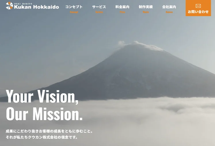 雲海の上にそびえる雄大な山を背景にしたウェブサイトのトップページ。企業ロゴ、ナビゲーション、「Your Vision, Our Mission.」というメッセージが配置されています。