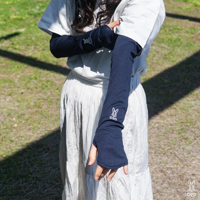 DODのウサギロゴが入ったネイビーのアームカバーを着用した女性