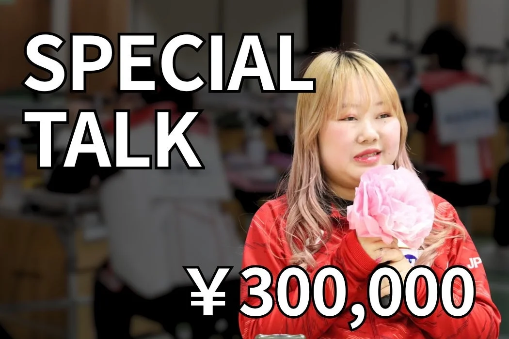 ブロンドとピンクの髪色の女性が赤いジャケットを着て話している様子