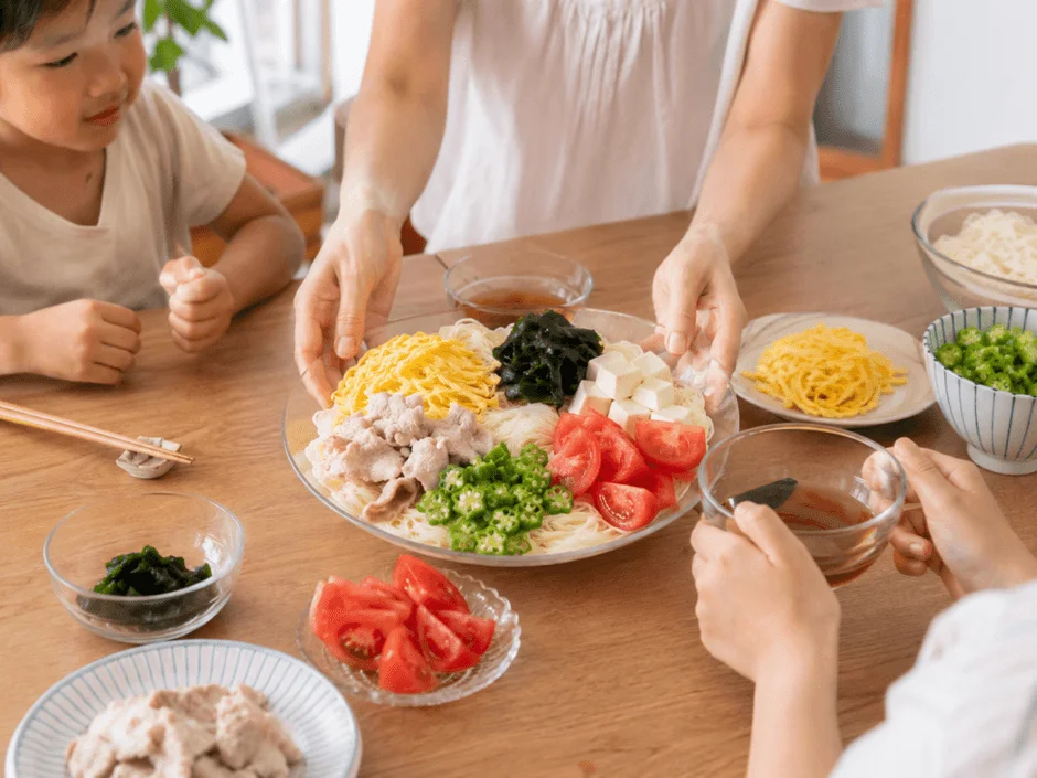 冷たい麺料理を囲む家族