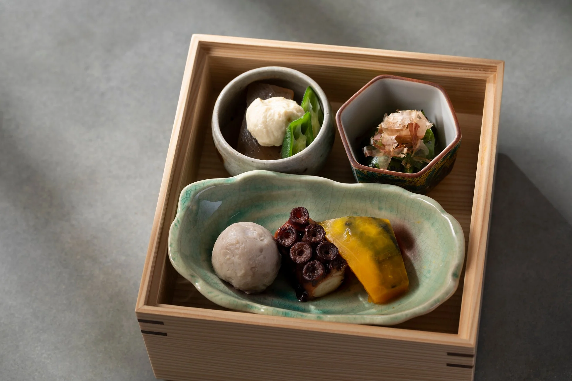 木製の箱に盛り付けられた和食の弁当です