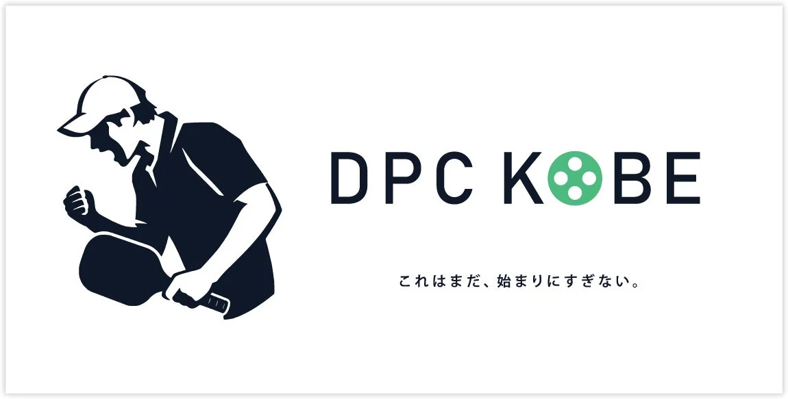 DPC KOBEのロゴ画像で、野球帽をかぶりパドルを持った人が拳を握りしめ、決意に満ちた表情をしています。KOBEの「O」はフィルムリールになっており、「これはまだ、始まりにすぎない。」というメッセージが添えられています。
