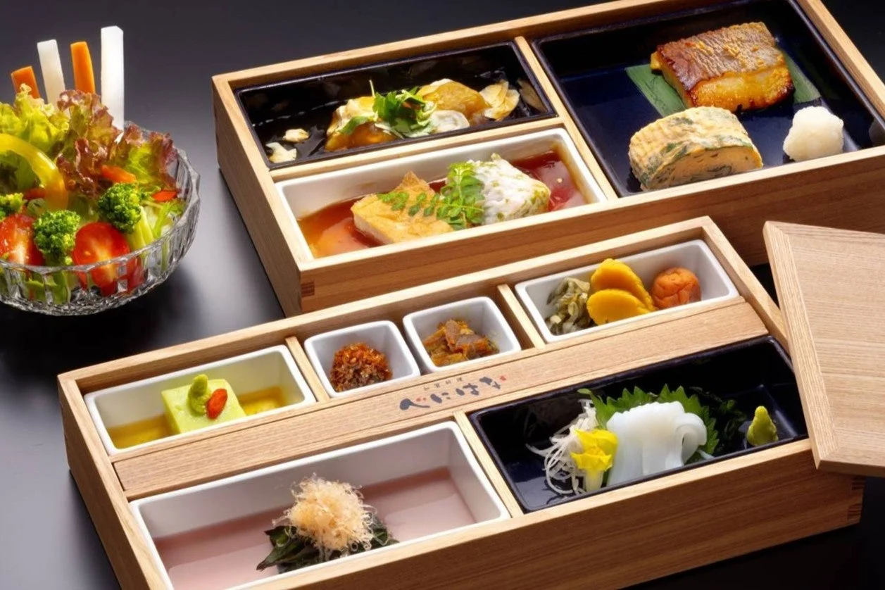 木製の箱に美しく盛り付けられた和食の御膳と、新鮮な野菜サラダが並んでいます。
