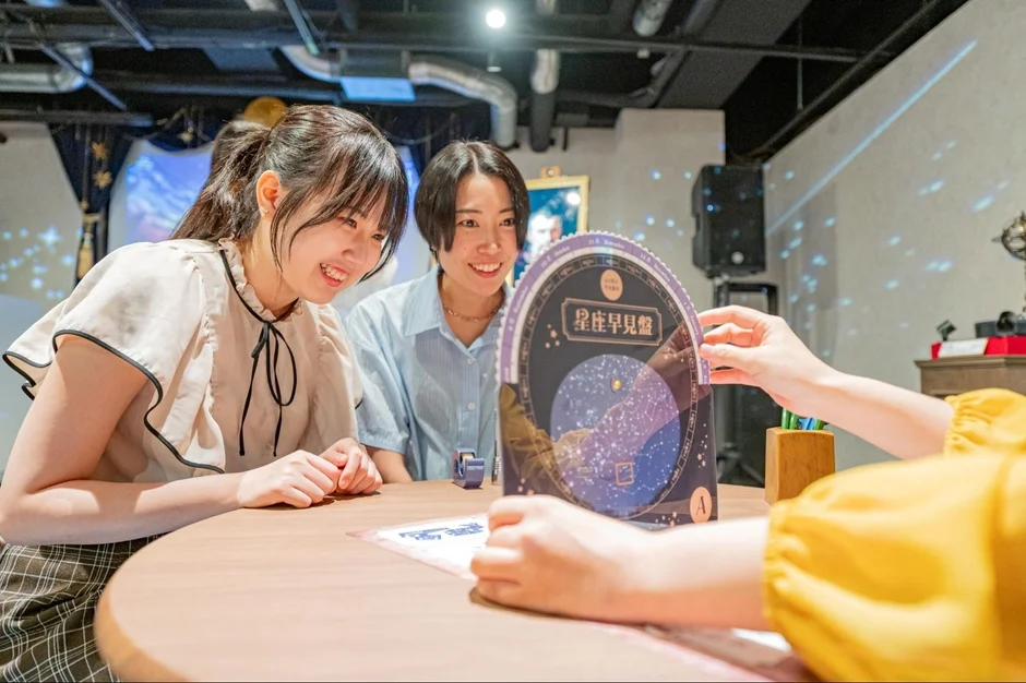 星座早見盤を覗き込む女性たち