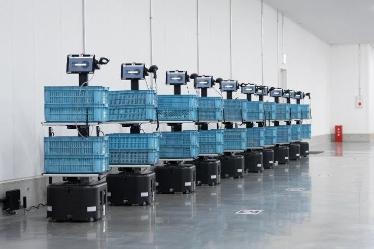 多数の自動搬送ロボットが並ぶ倉庫