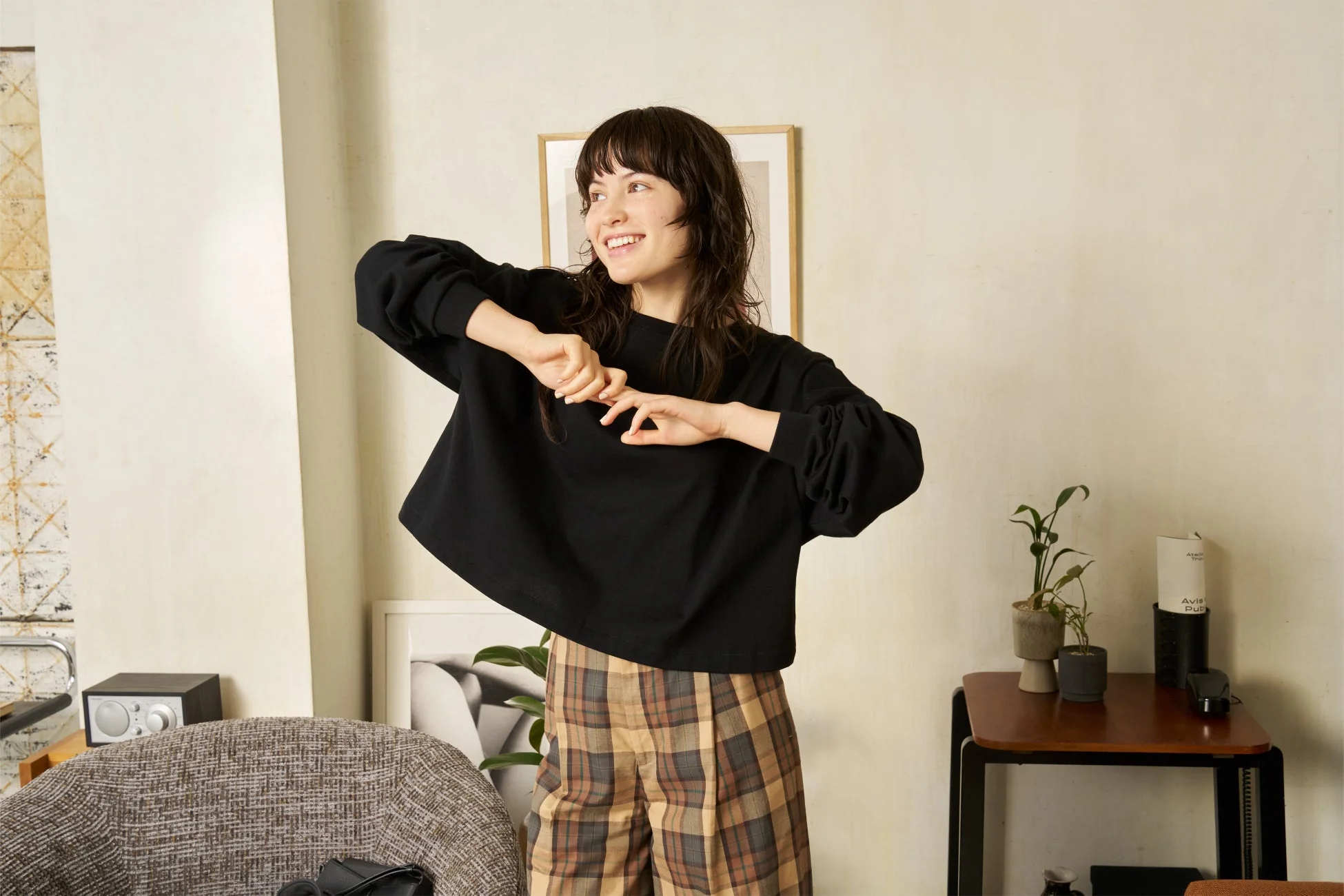 黒いトップスとチェック柄のパンツを着用した若い女性