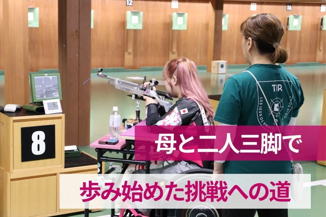 車椅子に乗った若い女性が屋内射撃場でライフル射撃の練習をしており、母親らしき女性が見守っている画像