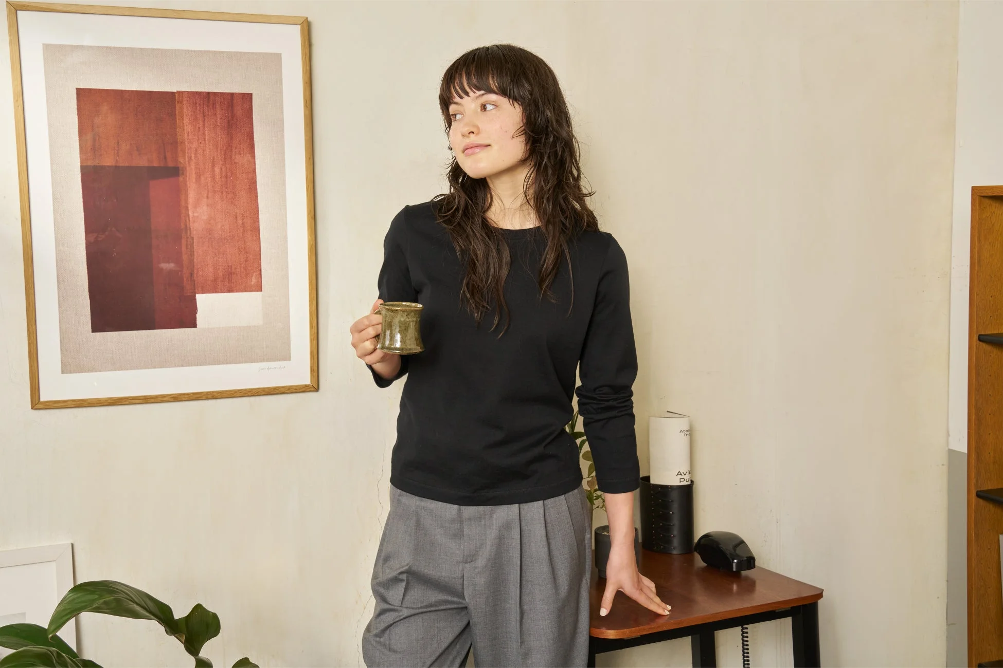 黒い長袖Tシャツとグレーのパンツを着用した女性