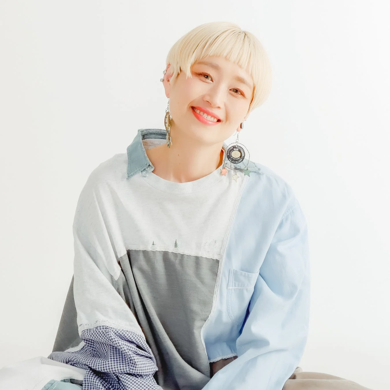 金髪のショートヘアが特徴の女性が、笑顔でカメラを見つめているポートレート写真