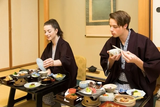 和室で日本料理を楽しむ着物姿の男女