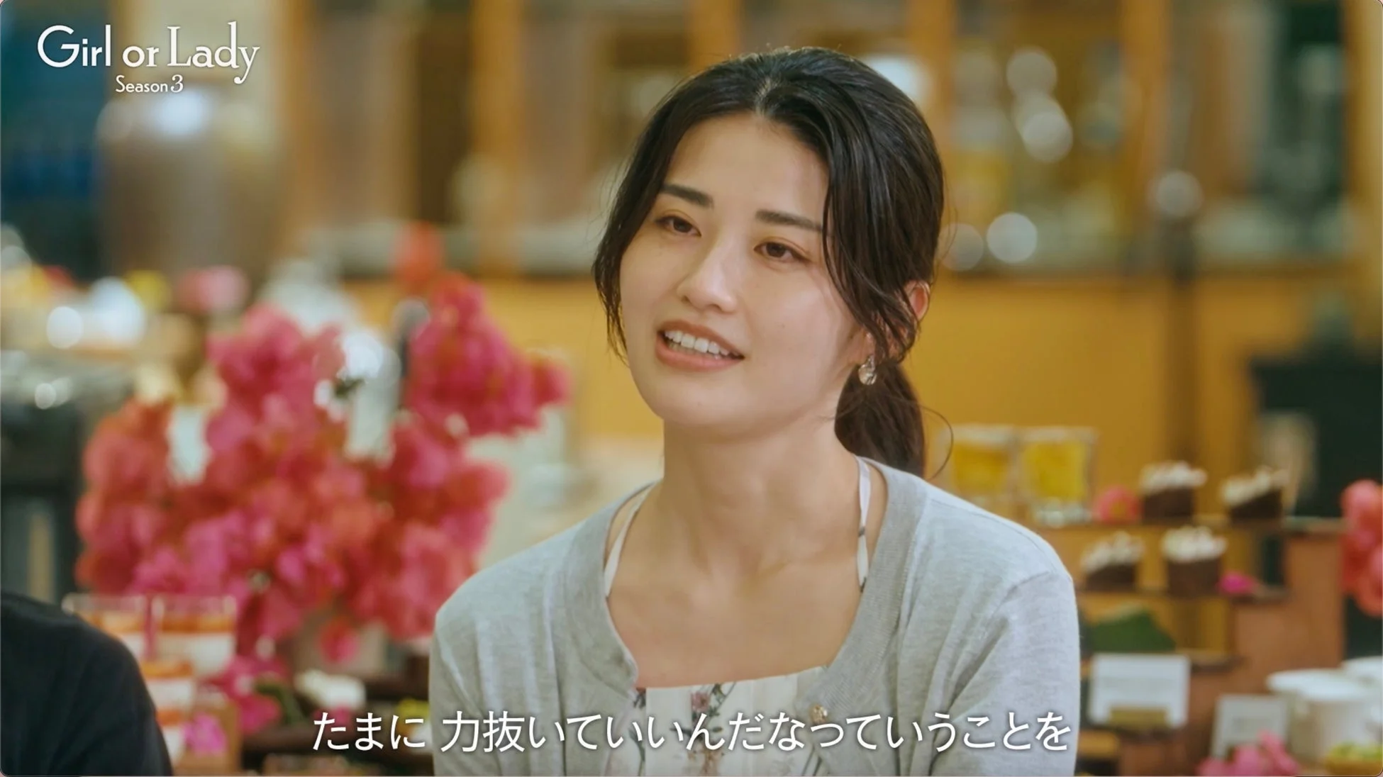 女性の笑顔、字幕「たまに力抜いていいんだなっていうことを」