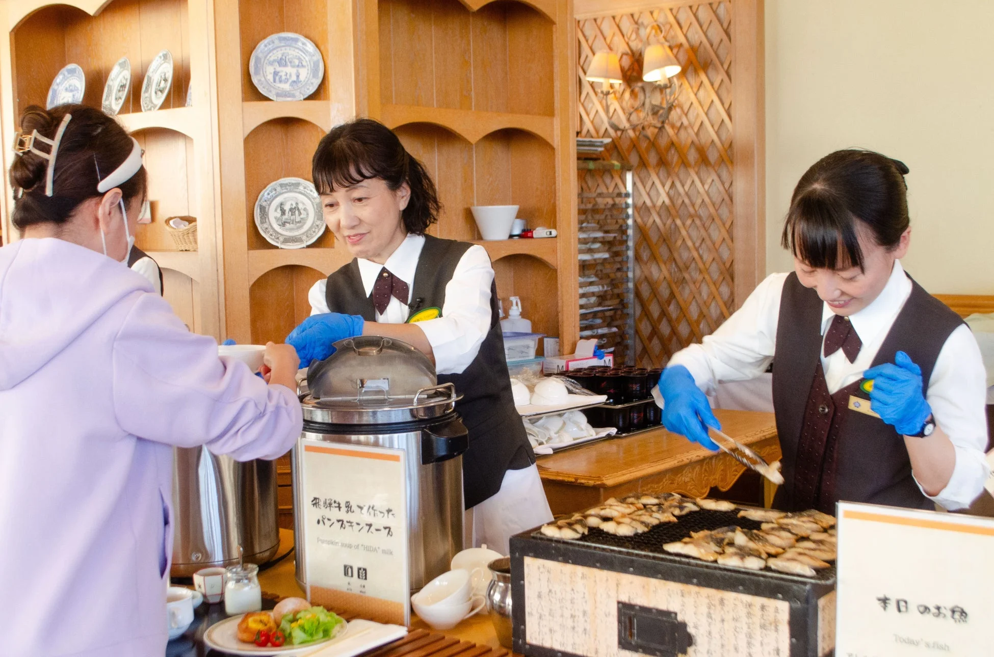ビュッフェで食事を提供するスタッフ