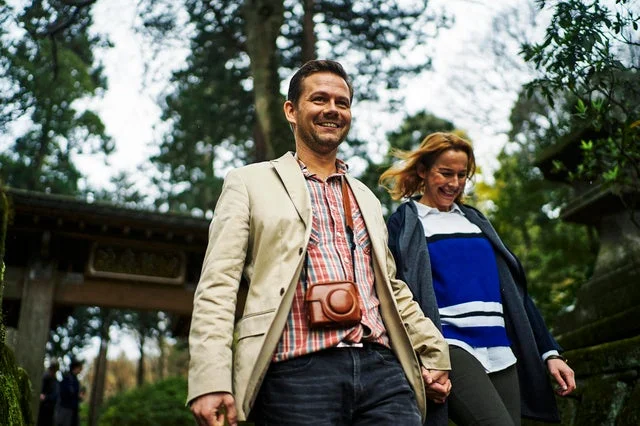 笑顔のカップルが日本の寺社らしき場所を散策する様子