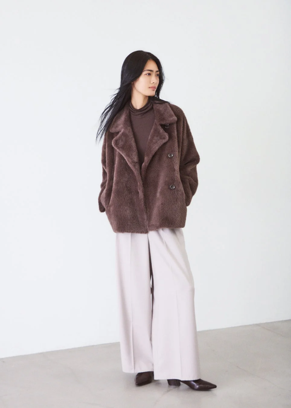 ブラウンのファーコートとベージュのワイドパンツ