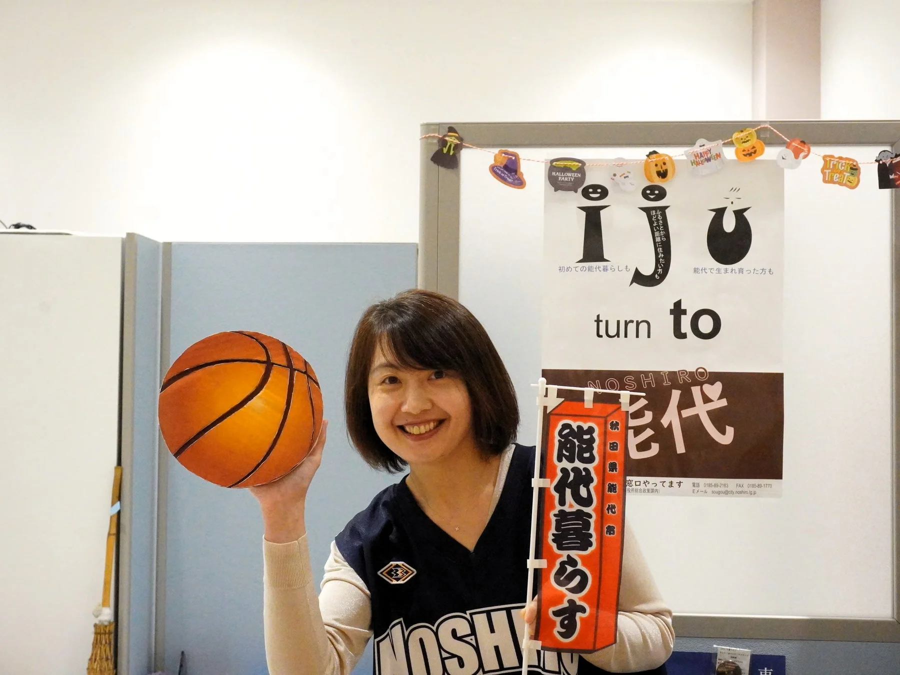 女性がバスケットボールと旗を持つ画像