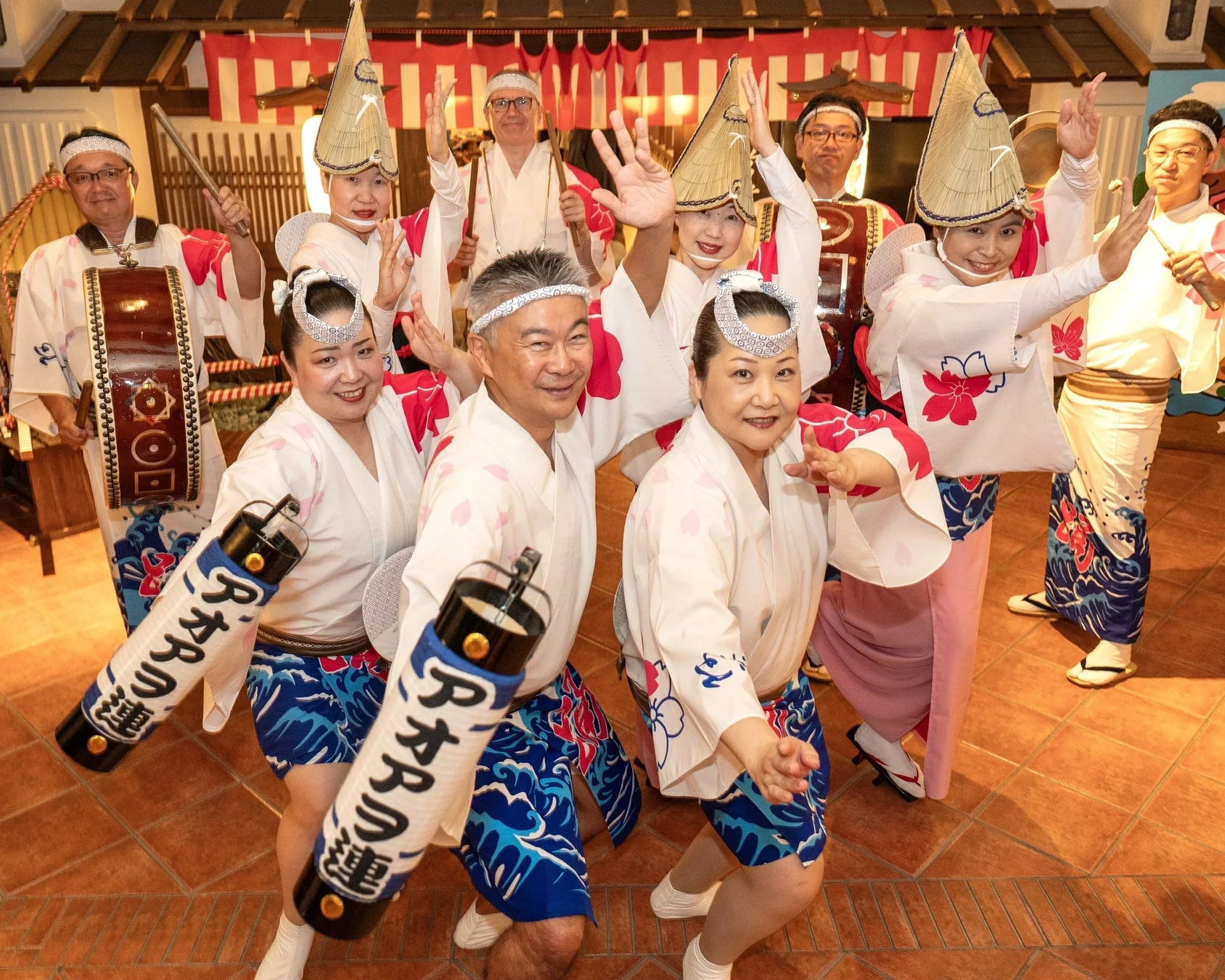 伝統的な衣装を身につけた人々が、阿波踊りのような活気あるパフォーマンスを披露