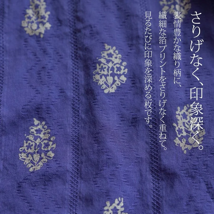 紫色の布地に織り柄と箔プリントが施されたテキスタイル