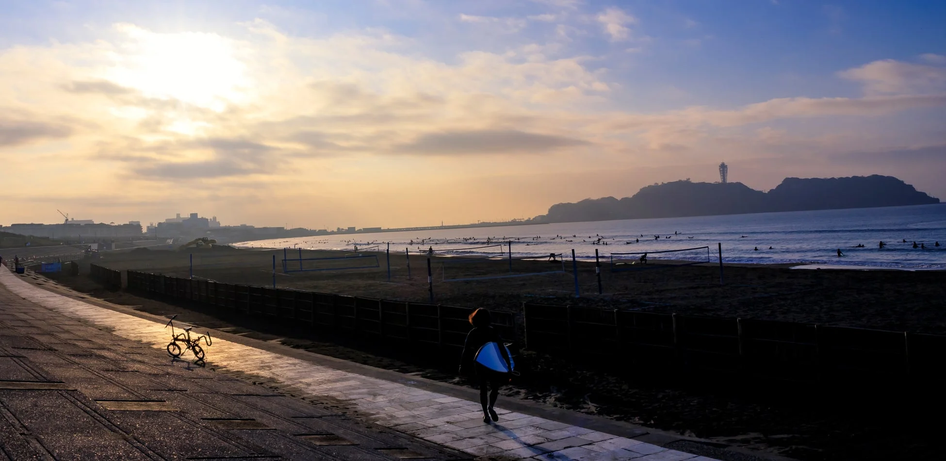 夕暮れの海岸でサーフィンを楽しむ人々