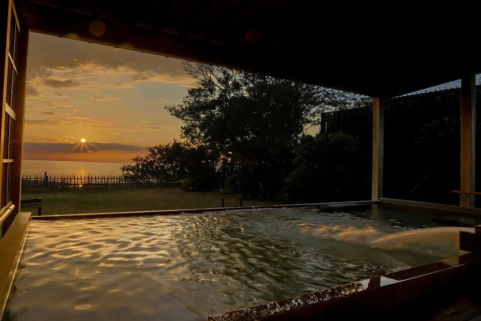 夕焼けに染まる海を望む露天風呂