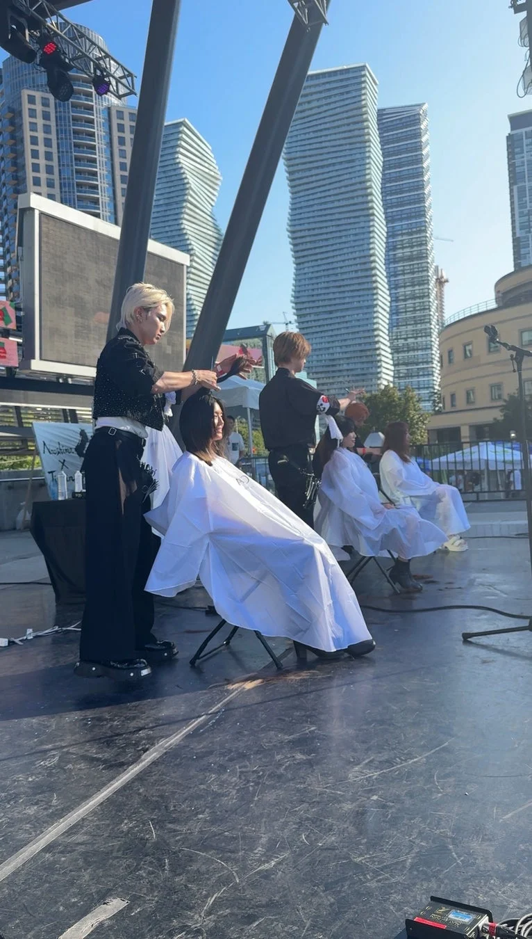 屋外ステージでのヘアカットイベント、スタイリストと客