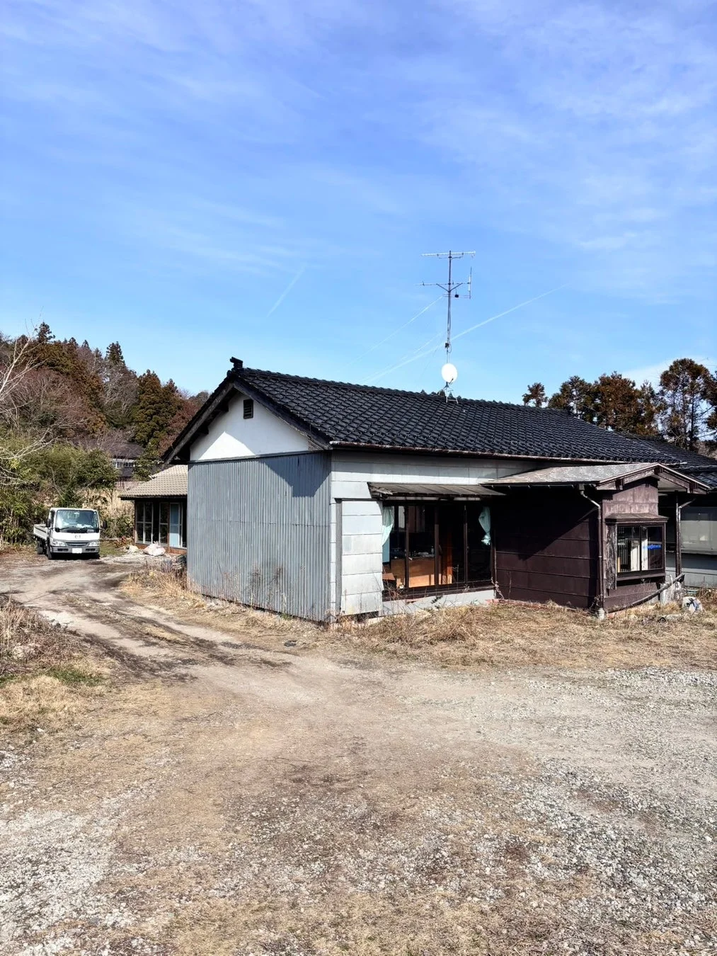古びた一軒家と軽トラック