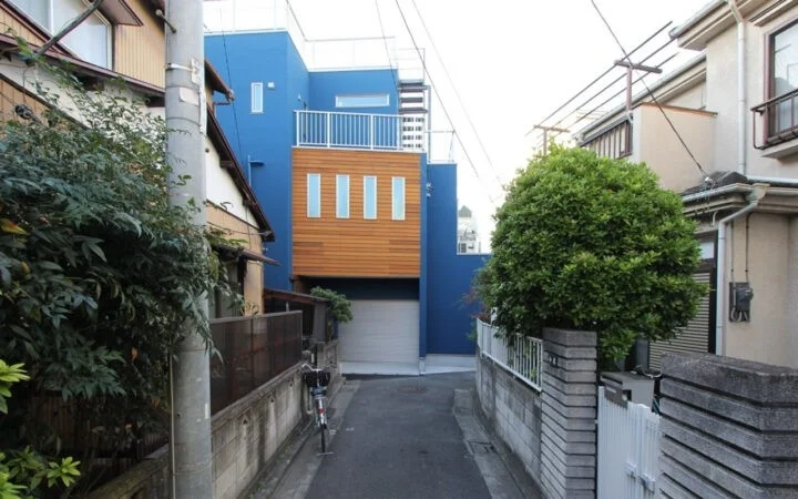 路地の奥に見える青い家