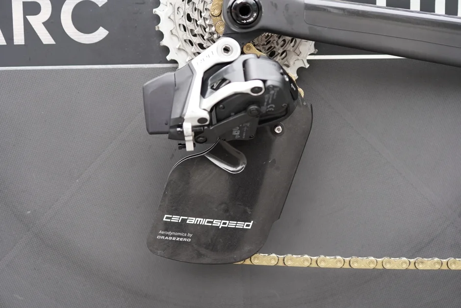 自転車の高性能なリアディレイラーとカセットスプロケット、ゴールドのチェーン。セラミックスピード製の大型プーリーケージシステム