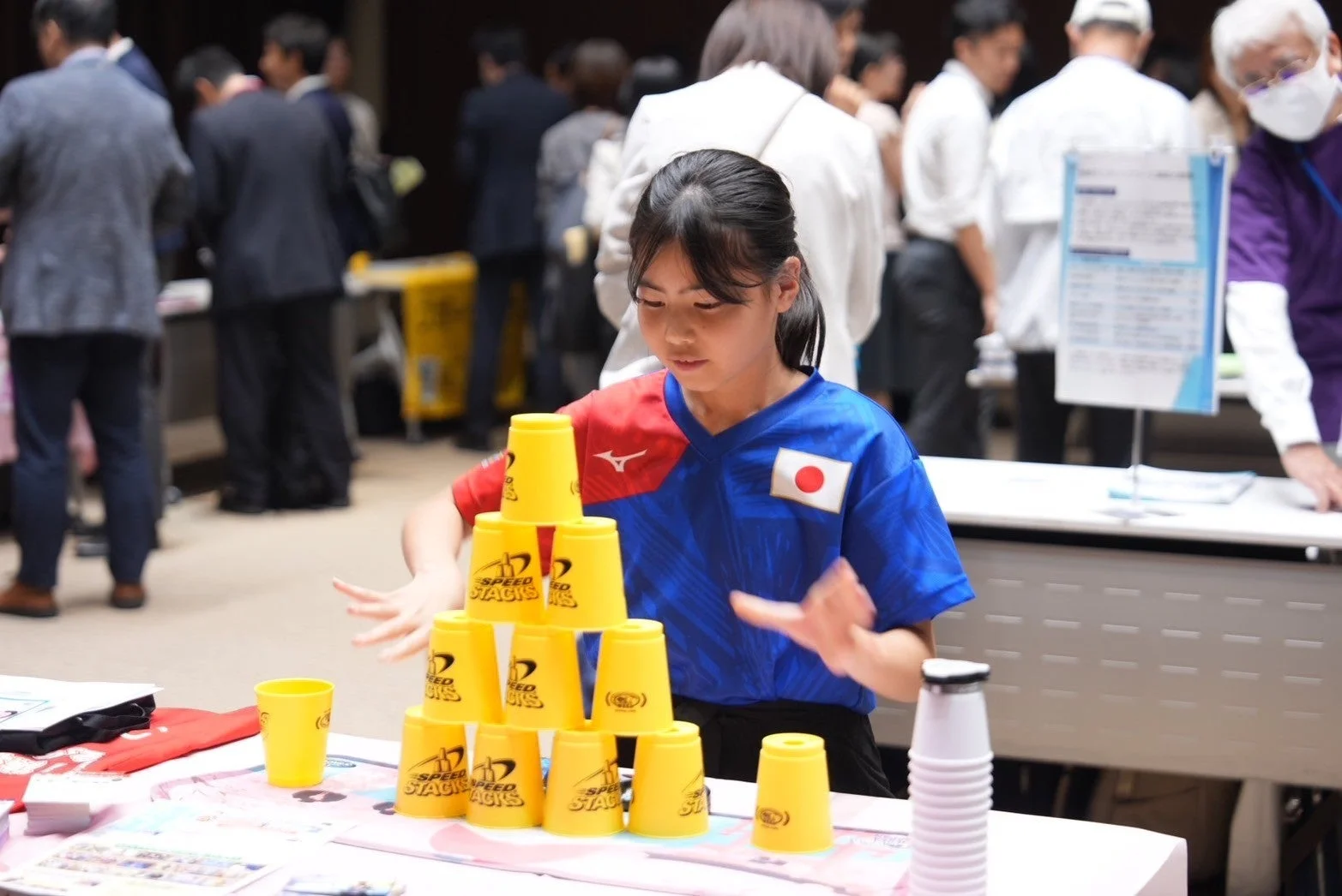 日本代表のユニフォームを着た少女がスポーツスタッキングに集中