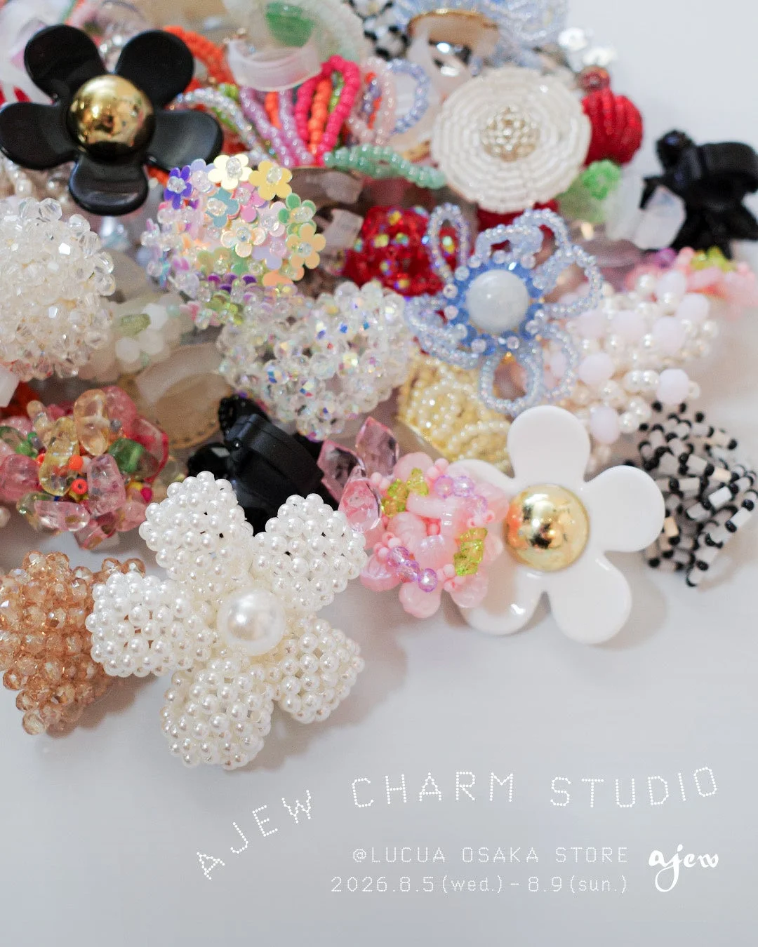 様々な色とデザインのビーズやパールで作られた花形チャームやアクセサリーが多数集められた画像