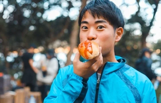 ホットドッグを食べる男性