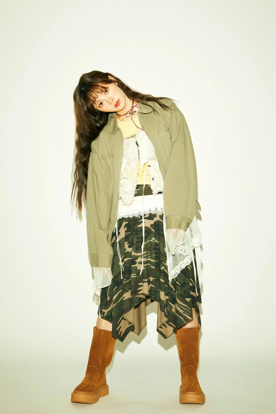 カーキのジャケット、迷彩柄のスカート、厚底ブーツを合わせた女性