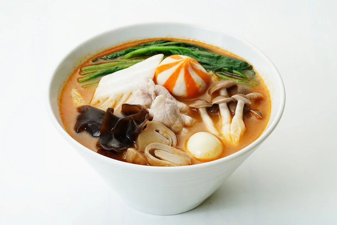 白っぽい器に盛られた、赤みがかったスープの温かい料理