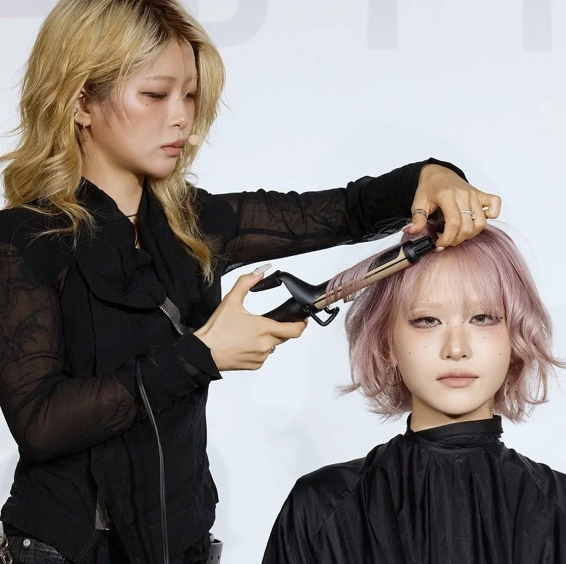 美容師がピンクヘアをスタイリング