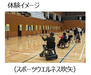 体育館で車椅子利用者を含む人々が吹矢を体験している様子