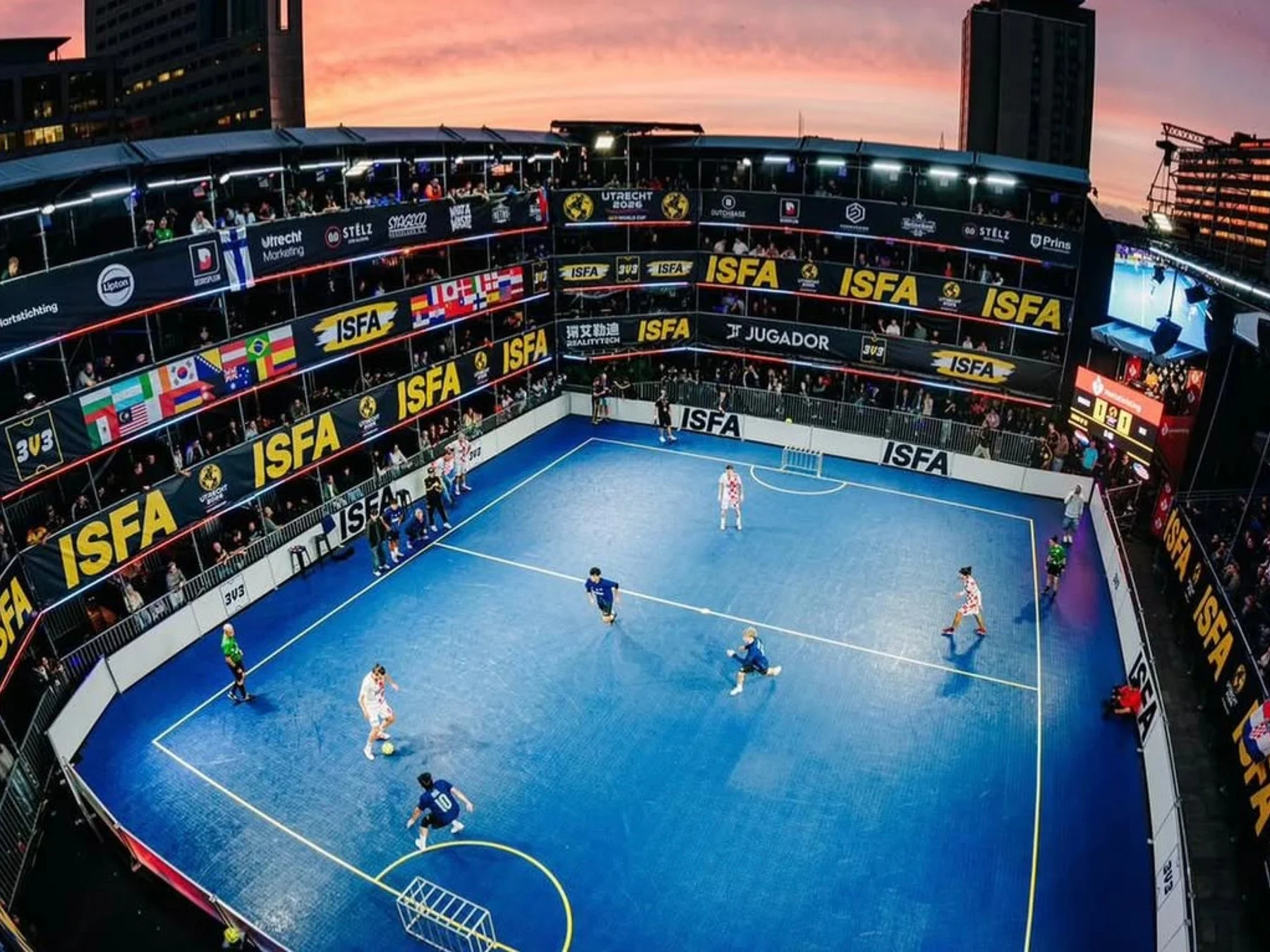 夕暮れ時の都市を背景に行われる3v3フットサルの試合風景