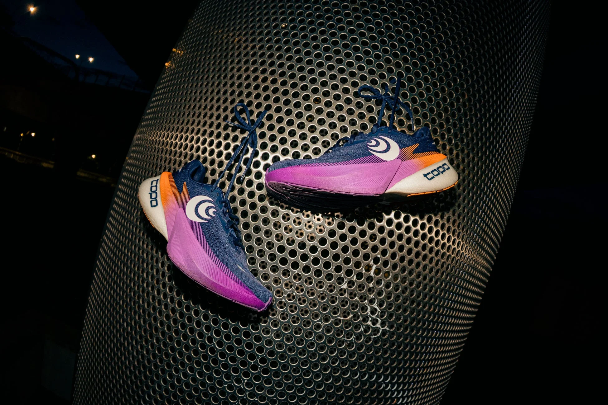 鮮やかな青、紫、オレンジ色のグラデーションが特徴的な「topo」ブランドのランニングシューズ
