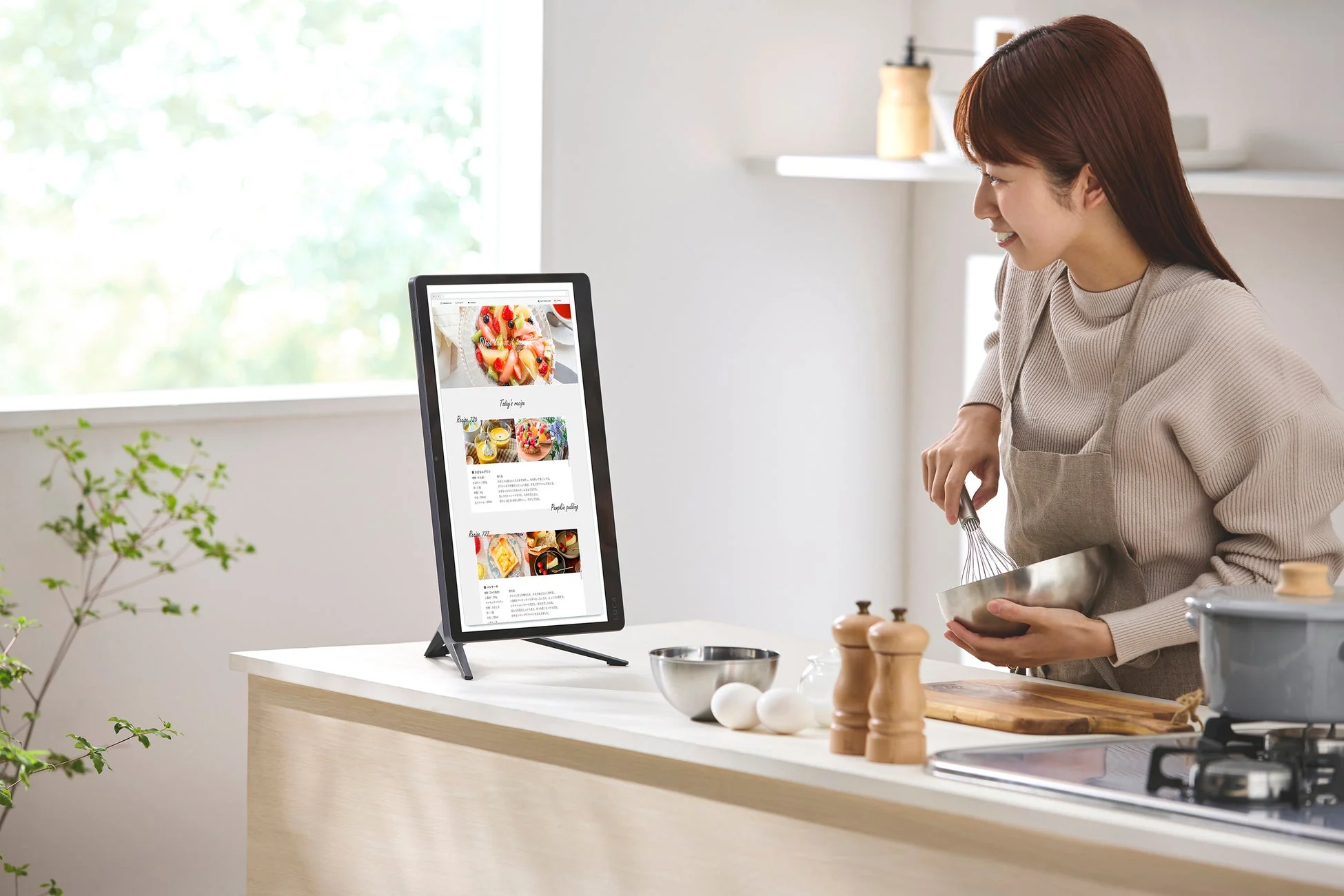 キッチンでレシピを見る女性とタブレットスタンド