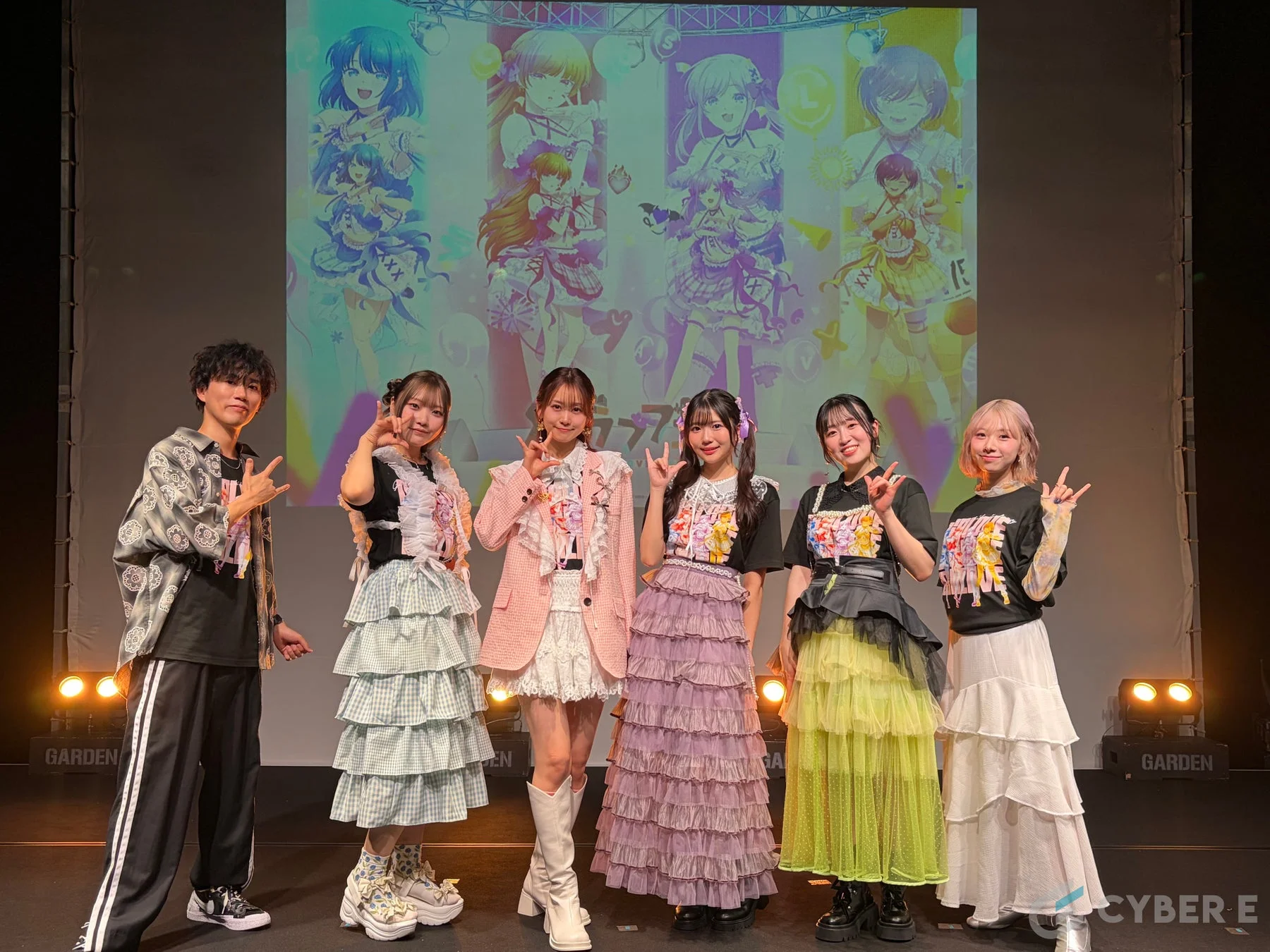 ステージ上でポーズをとる出演者たち